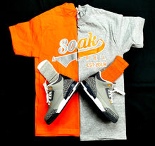 Load image into Gallery viewer, SOAK SHIRT shirt with orange and grey lettering 